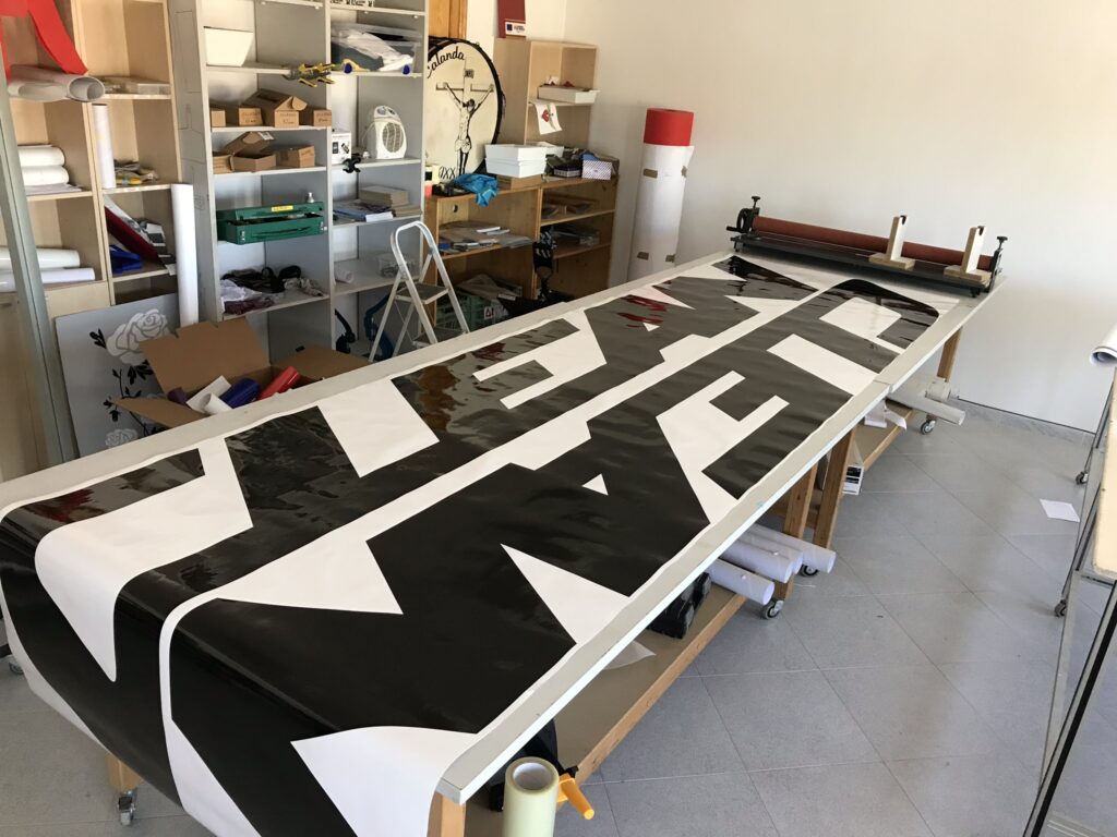 Taller de diseño gráfico trabajando en vinilos de gran formato personalizados, especializados en rotulación, impresión profesional y creación de soluciones visuales para vehículos, negocios y publicidad.