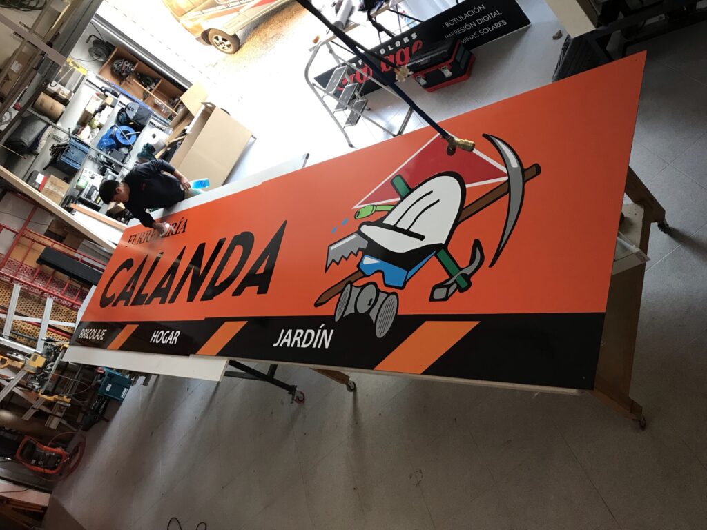 Taller de diseño gráfico realizando la fabricación de carteles y rótulos personalizados de gran formato, con impresión profesional para publicidad, negocios y proyectos de comunicación visual.