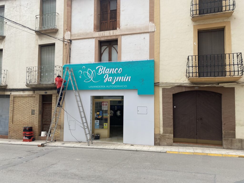Instalación profesional de lona publicitaria personalizada en fachada comercial, con diseño gráfico e impresión a gran formato para mejorar la visibilidad del negocio y potenciar la imagen corporativa.